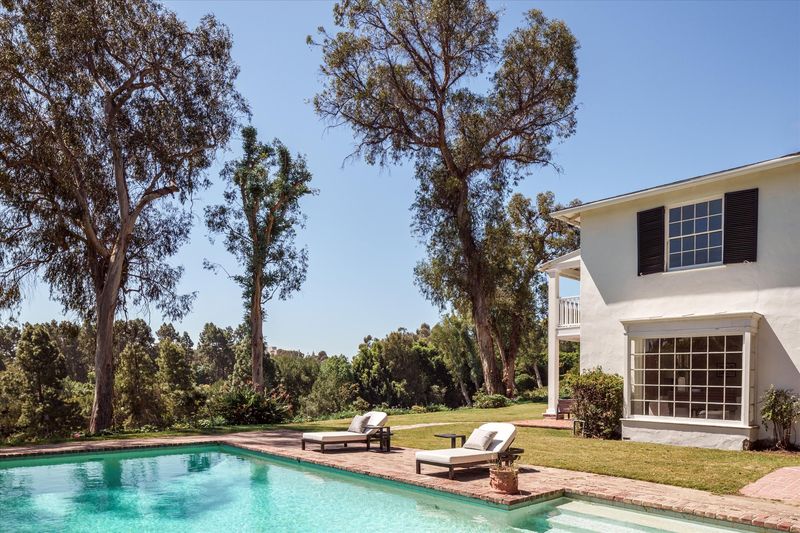 Pool and white Colonial-style house at 10810 Ambazac Way, Bel Air