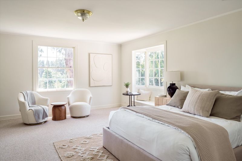 Bedroom with armchairs and windows on two sides at 10810 Ambazac Way, Bel Air — photo 12 of 12