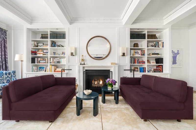 Fireplace wall with flanking bookshelves at 1100 Park Avenue 6B, Carnegie Hill — photo 2 of 10