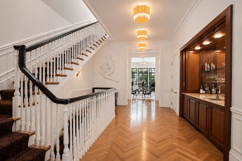 Entry hall with wet bar and herringbone floors at 111 East 81st Street, Upper East Side — photo 7 of 8