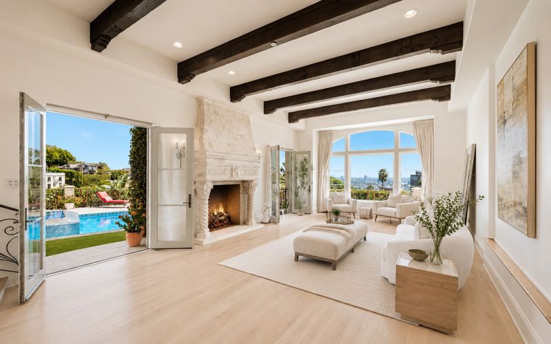 Living room with a fireplace and views to the pool at 1260 St Ives Place, Bird Streets, Hollywood Hills — photo 4 of 6