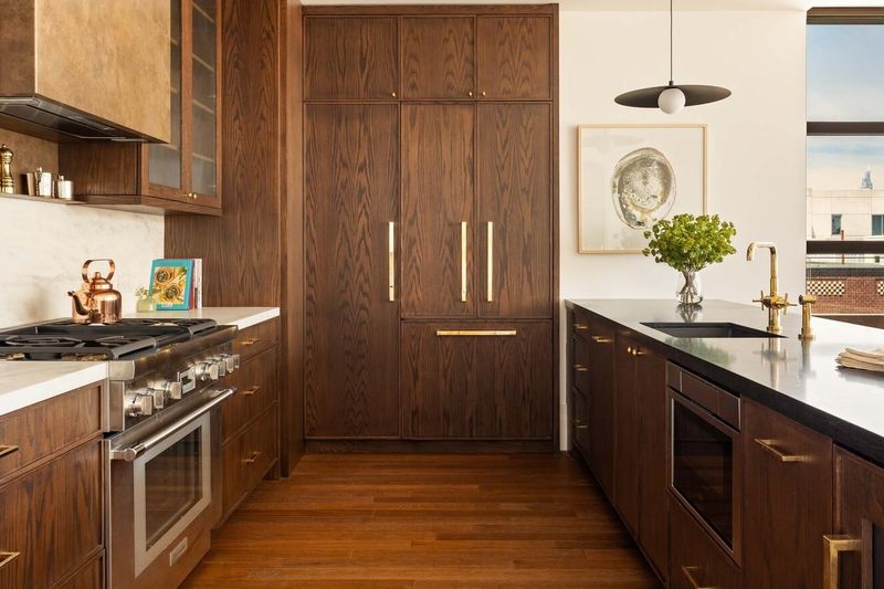 Walnut kitchen with brass range hood at 127 Kent Avenue PH1A, Williamsburg — photo 3 of 8