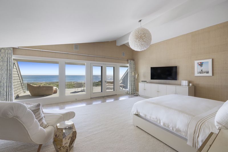 Bedroom with a wall of glass facing the ocean at 137 Murray Lane, Southampton Village — photo 6 of 10