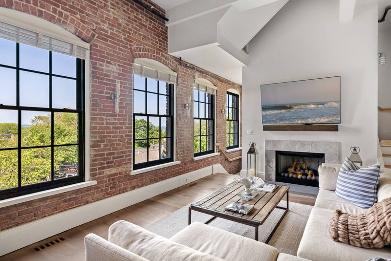 Living room fireplace, arched brick windows at Watchcase, 15 Church Street PH-402, Sag Harbor Village — photo 3 of 8