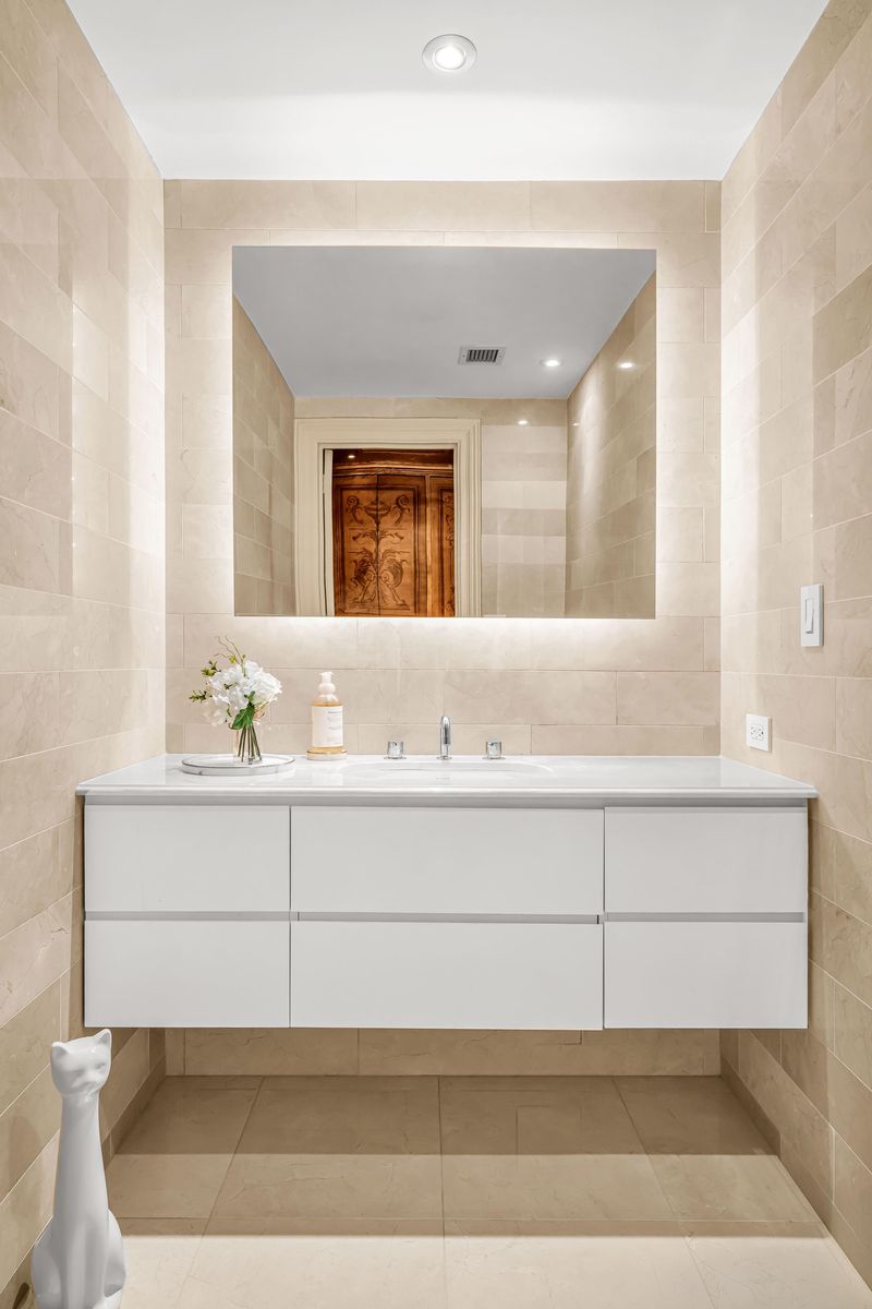 Bath with floating white vanity and backlit mirror at 160 Central Park South 915, Central Park South — photo 6 of 6