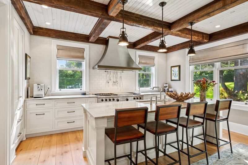 Cook's kitchen with island and range hood at 2 Borden Lane, East Hampton — photo 6 of 12