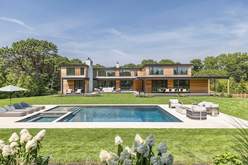Pool and lawn in front of the cedar-clad modern at 204 Head of Pond Road, Water Mill