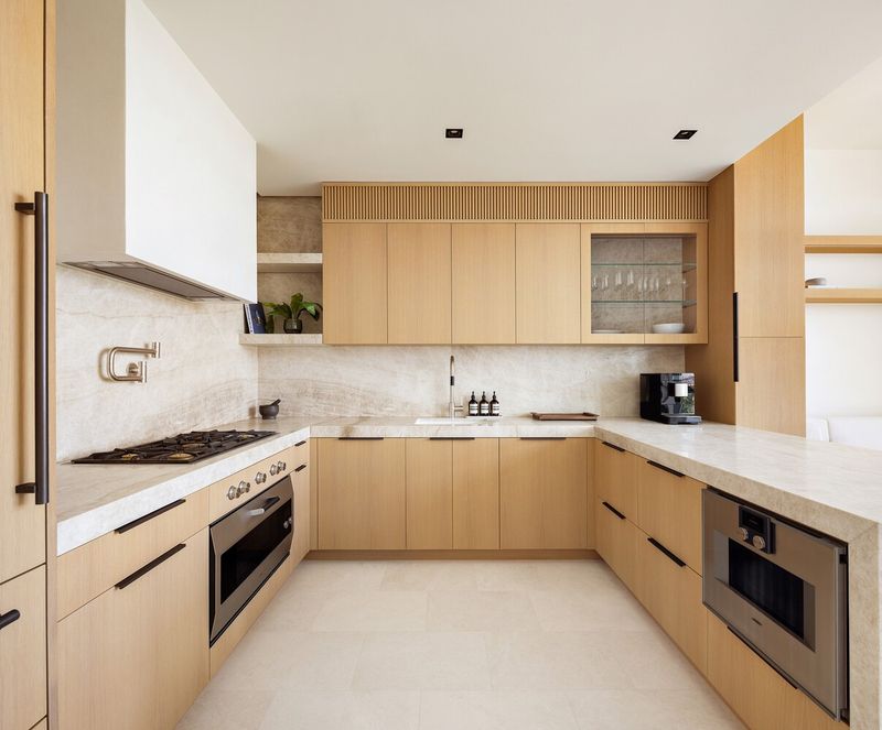 Chef's kitchen with rift white oak cabinetry and Taj Mahal quartzite at 290 West Street 5B, Tribeca — photo 3 of 12