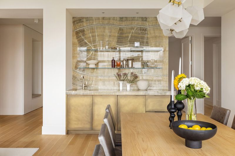 Custom Amuneal bar in mottled brass with onyx and illuminated glass shelving at 290 West Street 5B, Tribeca — photo 5 of 12