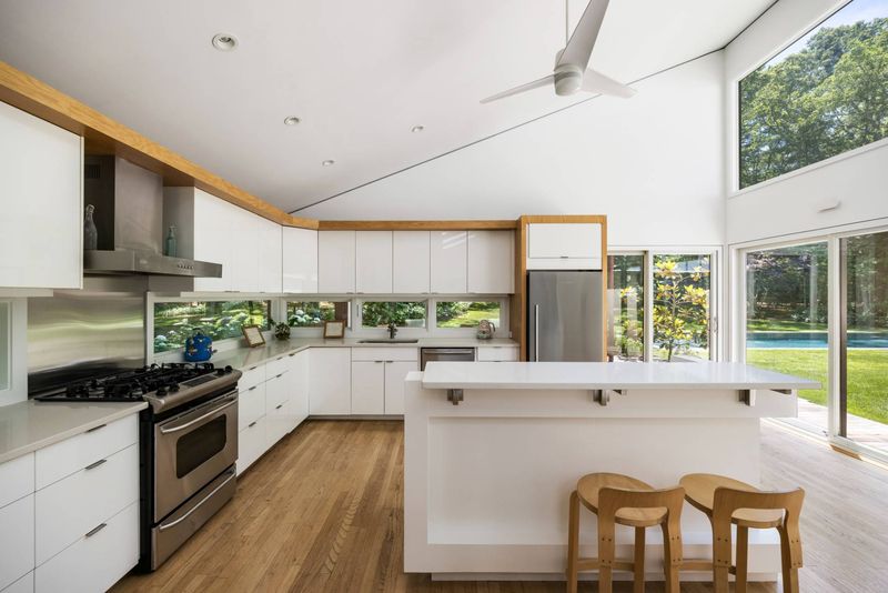 Oak and white kitchen to pool at 3 Whale Rock Lane, East Hampton — photo 5 of 8