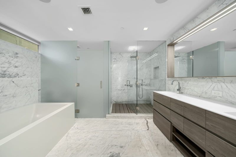 Marble primary bath with glass shower at Beach House 200, 321 Ocean Drive, Miami Beach — photo 6 of 8