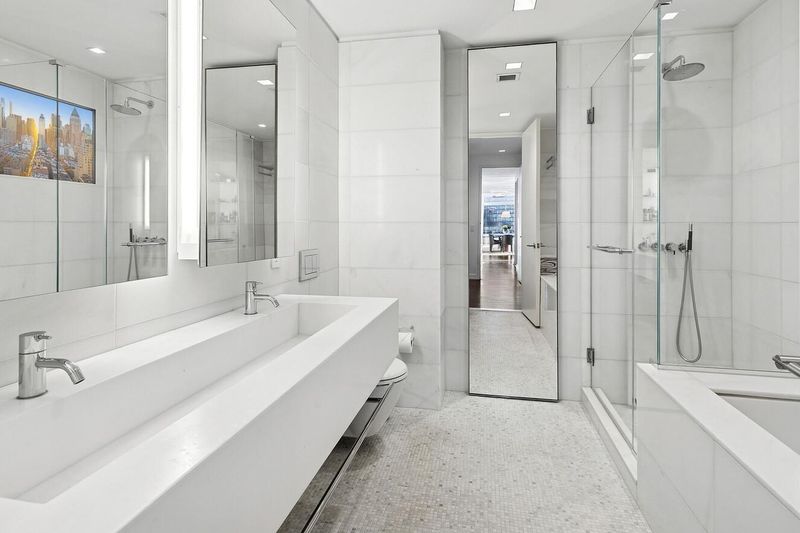 Primary bath with marble walls, trough sink and soaking tub at 400 East 67th Street 27A, Lenox Hill — photo 6 of 8
