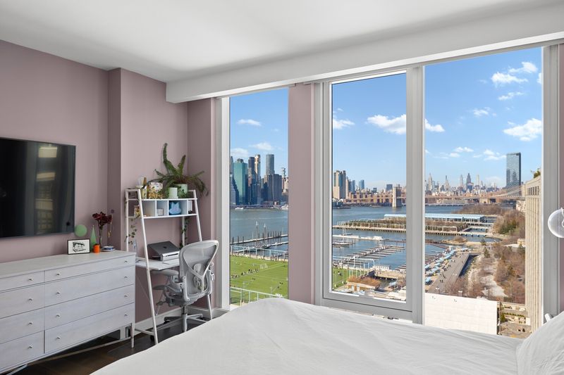 Primary bedroom with views toward the Manhattan and Brooklyn bridges at 50 Bridge Park Drive 16B, Brooklyn Heights — photo 4 of 12