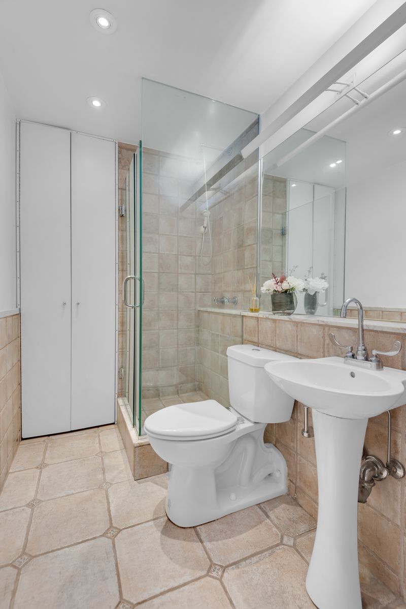 Bath with a glass-enclosed shower at 55 East 86th Street 8B, Carnegie Hill — photo 7 of 9