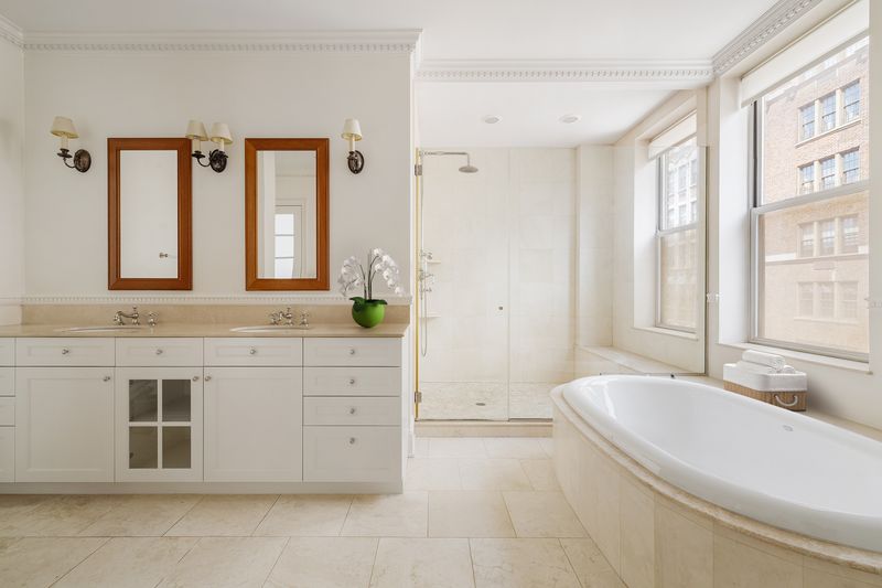 Primary bath with soaking tub and double vanity at 876 Park Avenue 9N, Upper East Side — photo 3 of 12