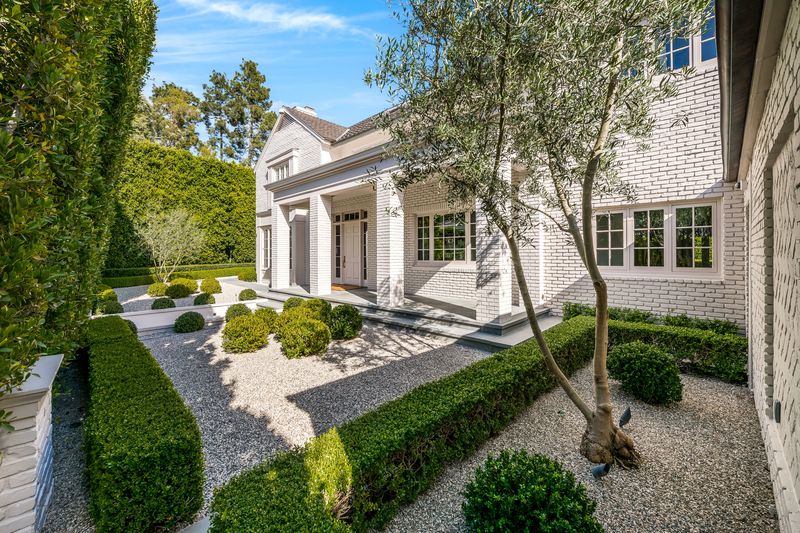 White brick facade and formal portico entry at 9551 Lime Orchard Road, Beverly Hills